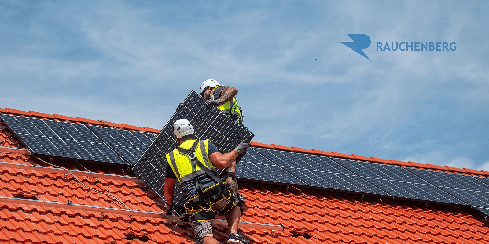 Montážní tým instaluje fotovoltaický panel na střechu výrobního areálu. 