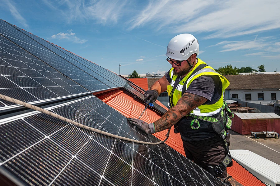 Servisní technik montuje FVE panel na střeše